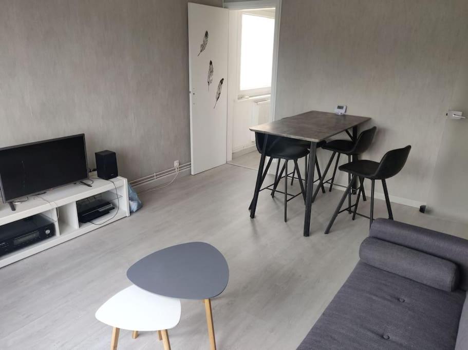 un salon avec une table, des chaises et un canapé dans l'établissement Appartement Calais centre (+ parking gratuit), à Calais