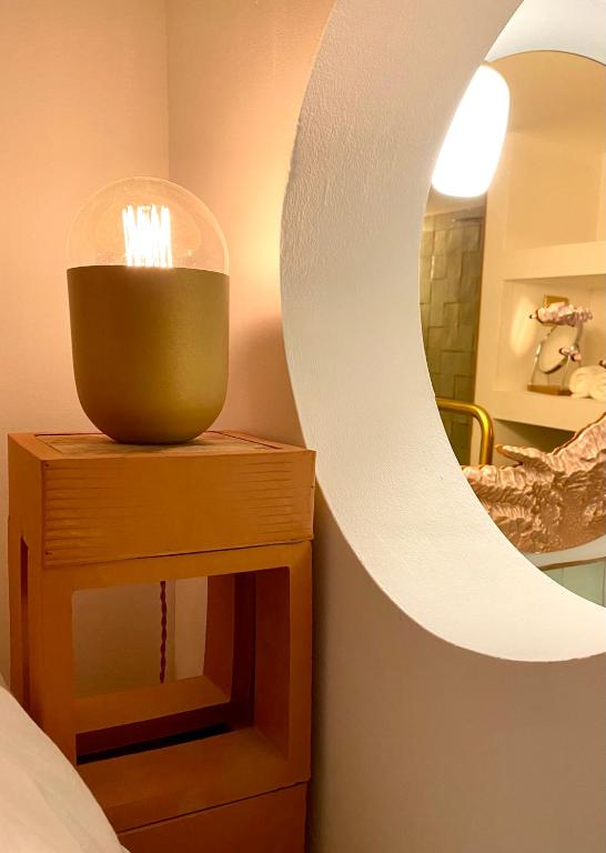 a bathroom with a mirror and a table with a candle at L&#39;Annexe de la Madrague Marseille in Marseille