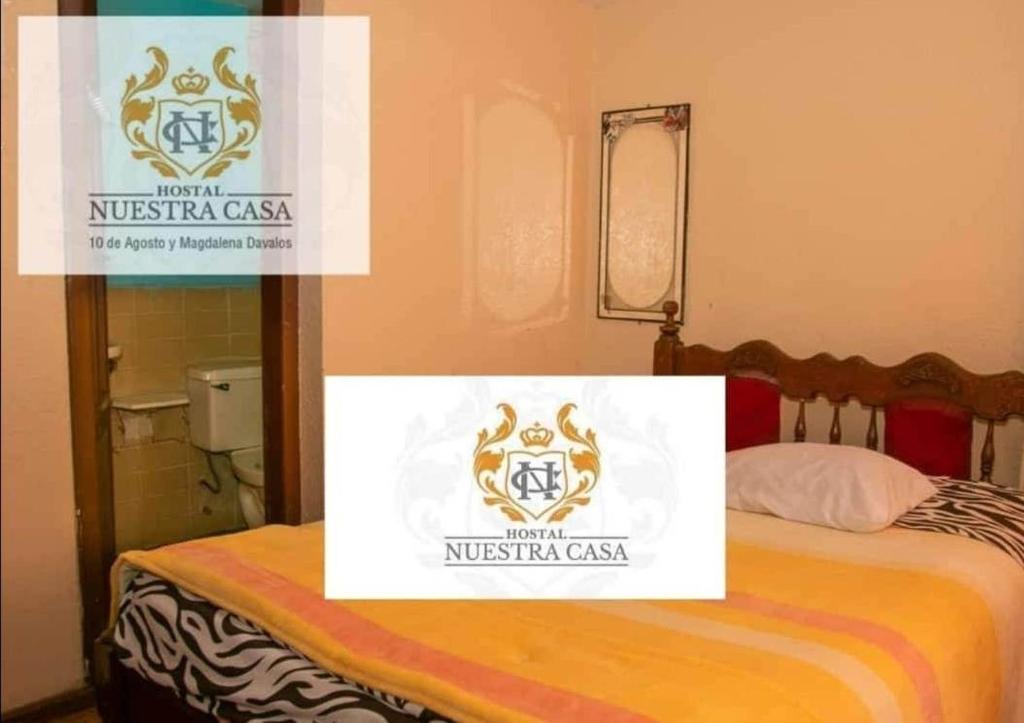 Una habitación con una cama con un cartel. en Hotel Nuestra Casa Riobamba, en Riobamba