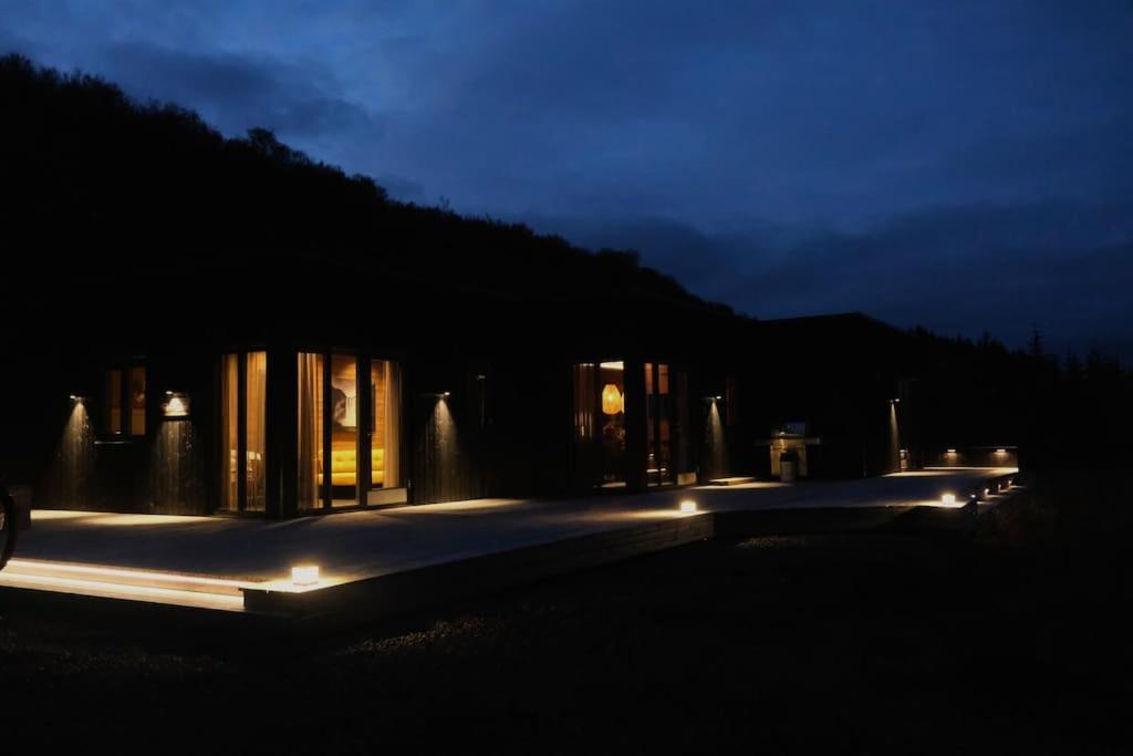 a house lit up at night with lights at Luxury 2-Bedroom Lodge in the South of Iceland in Reykholt