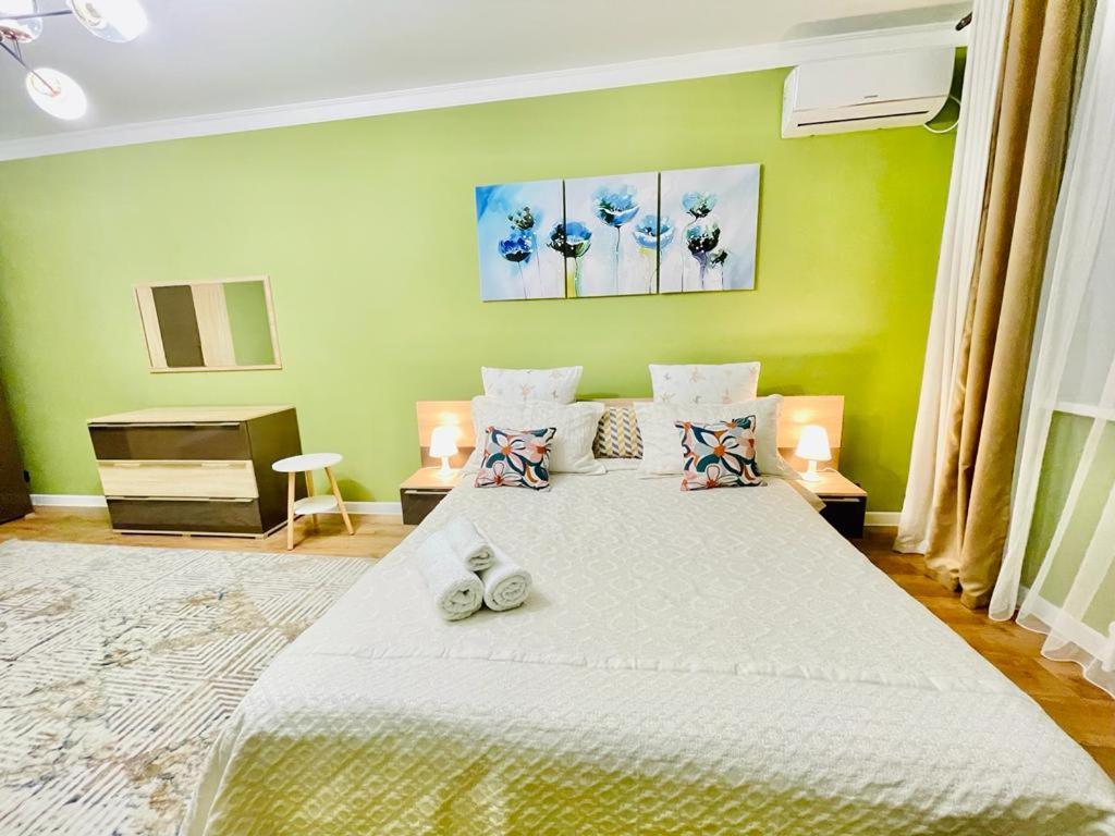 a bedroom with a large bed with two shoes on it at # 22 Яркая и уютная квартира MODERN in Atyrau