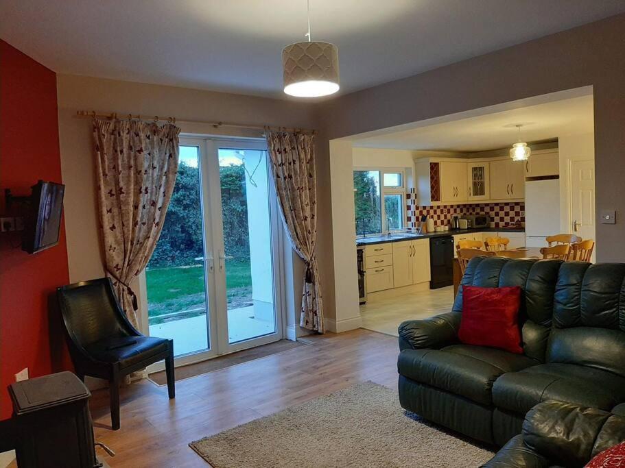uma sala de estar com um sofá e uma cozinha em Family Home, 20 mins from Youghal Beach em Killeagh