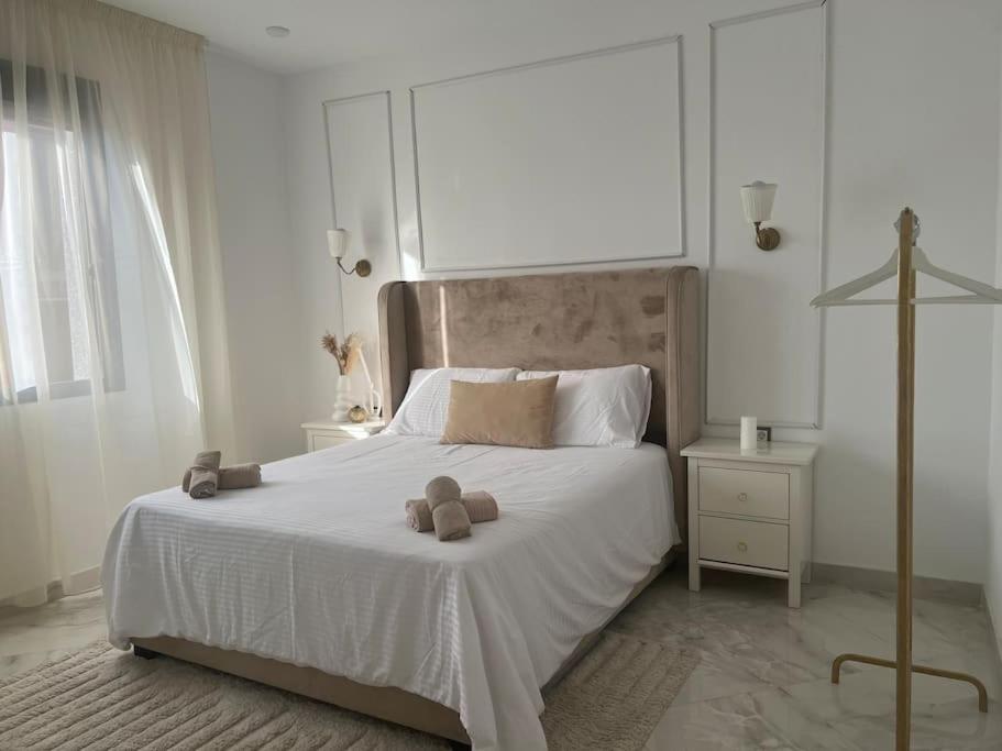ein Schlafzimmer mit einem weißen Bett mit zwei Teddybären darauf in der Unterkunft Luxueux T3 à Oran. in Oran