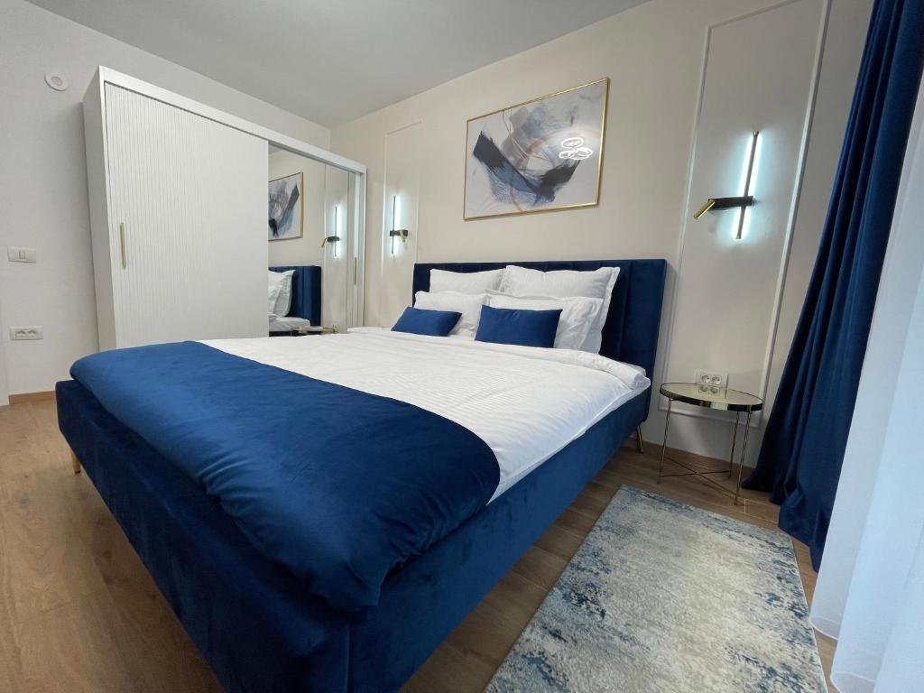 un letto blu e bianco in una camera d'albergo di Florilor Residence II a Piteşti