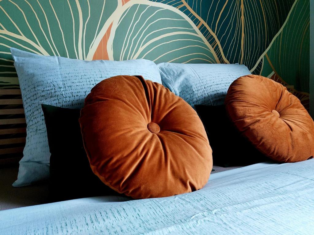 a bed with two orange pillows on it at Avou nozôtes in Namur