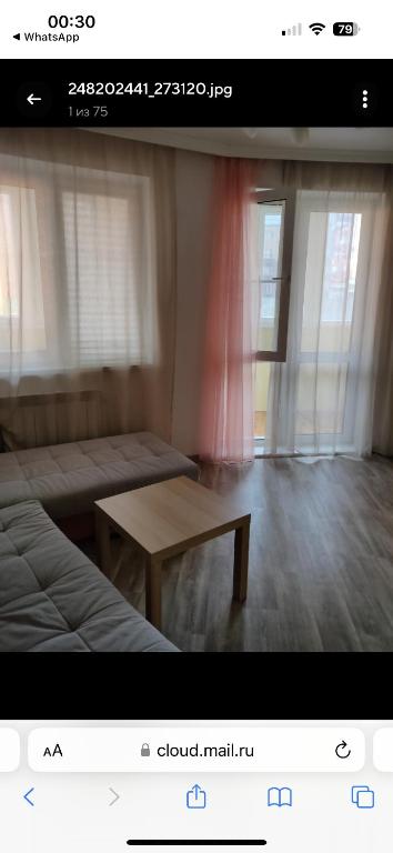 um quarto com uma cama, uma mesa e janelas em VIP apart 370 em Tbilisi