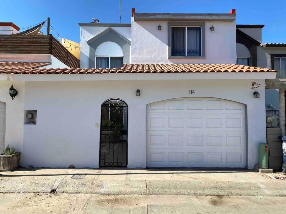 Casa blanca con una gran puerta de garaje en Casa para toda la familia, en Ensenada