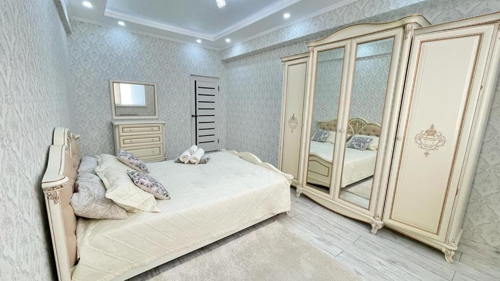 um quarto com uma cama grande e um espelho em # 268 Светлая и уютная квартира em Atyrau