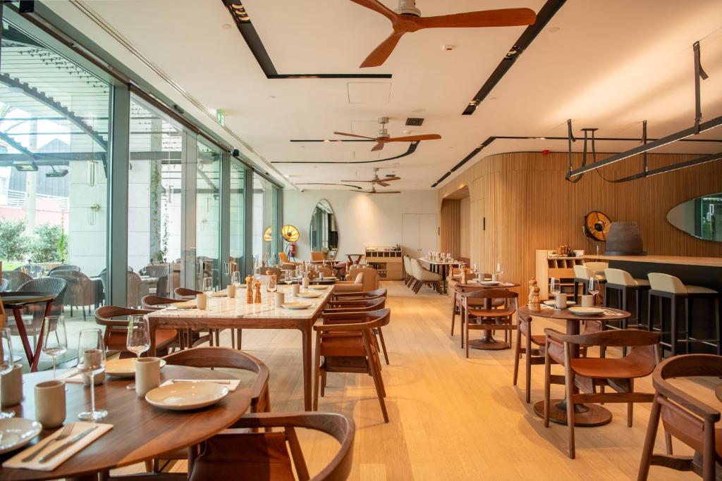 a restaurant with wooden tables and chairs and windows at EVOLUTION Cascais-Estoril Hotel in Estoril