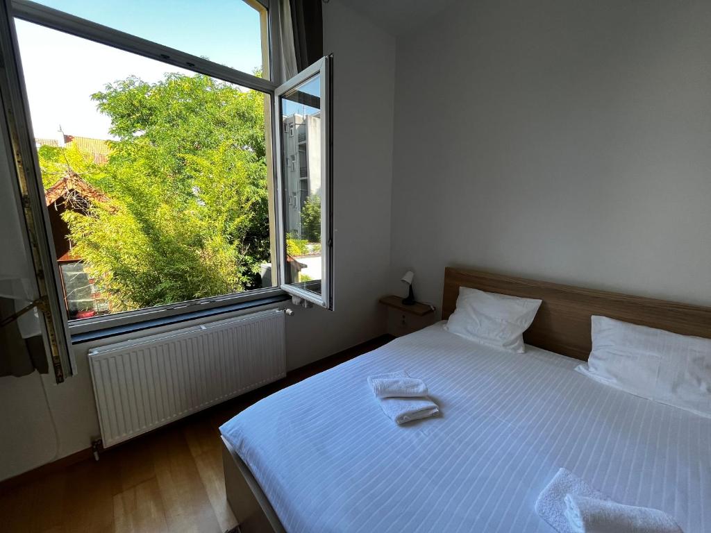 um quarto com uma cama branca e uma grande janela em L&L apartment em Bruxelas