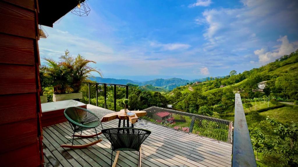 - un balcon avec une table et des chaises sur une terrasse en bois dans l'établissement Glamping Idilio, à Llanitos