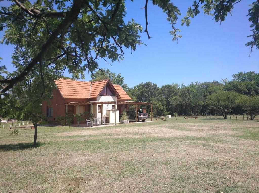 ein Gebäude auf einem Feld mit Bäumen im Hintergrund in der Unterkunft Cabañas el Ñato in Nono