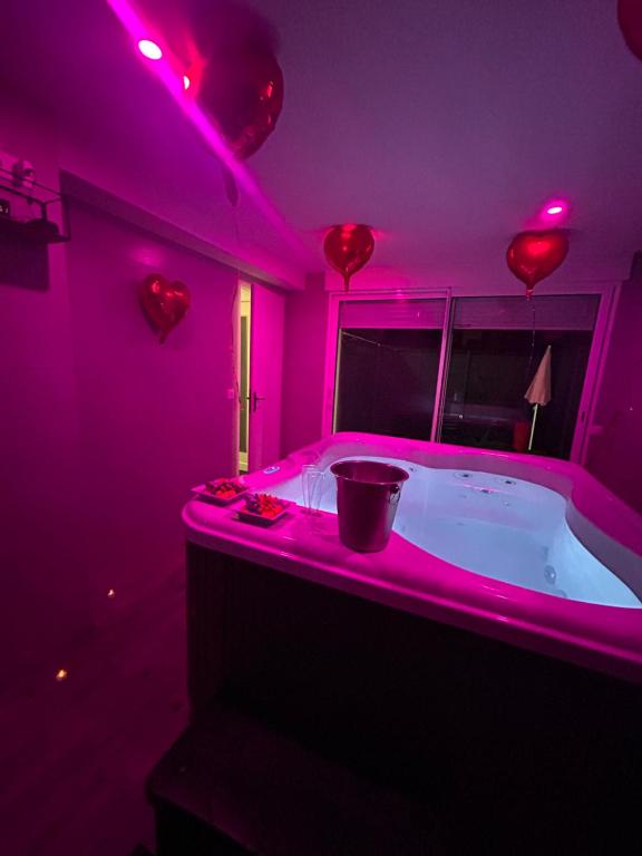 um quarto roxo com uma banheira com um balde em Jacuzzi privé arrivée autonome em Conflans-Sainte-Honorine