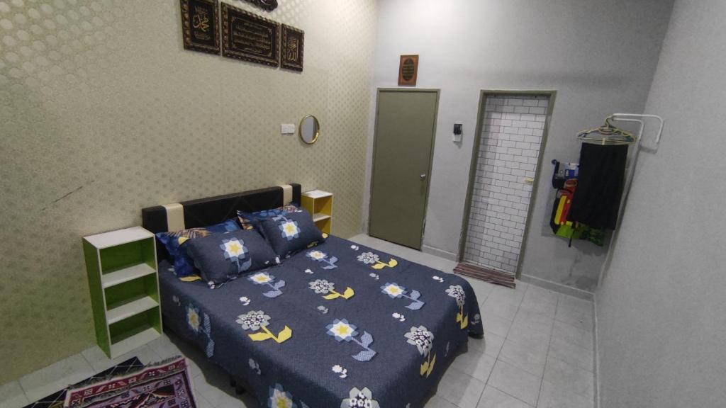 a bedroom with a bed with a blue comforter at Homestay Ara Kaseh in Mersing