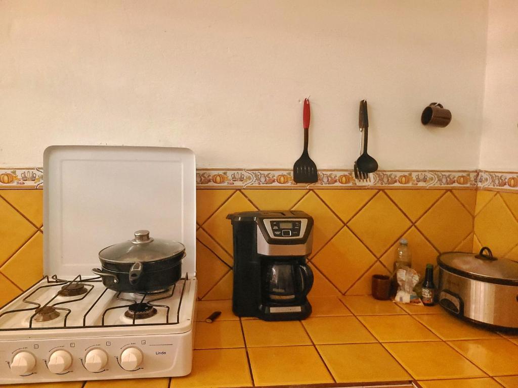 um balcão de cozinha com um fogão e comodidades para preparar café em Hostel Rossy em San Juan del Sur