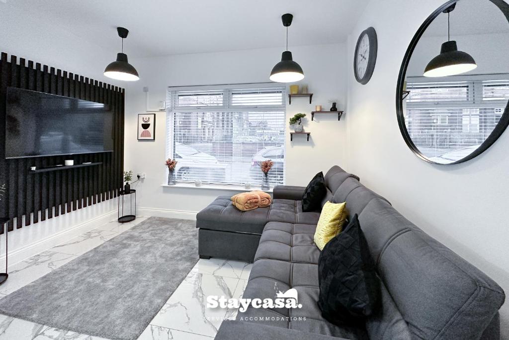 a living room with a gray couch and a large mirror at Luxurious 1 Bedroom Apartment Sleeps 3-4 in Manchester