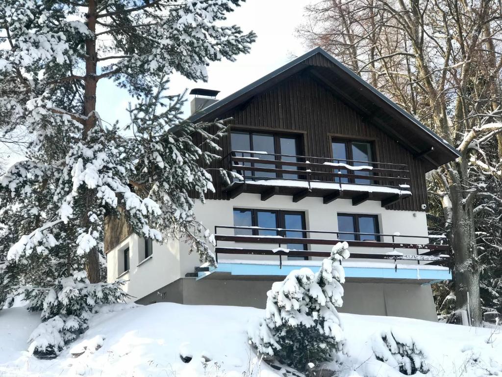 une maison recouverte de neige dans les bois dans l'établissement Tri Lipy, à Vítkovice