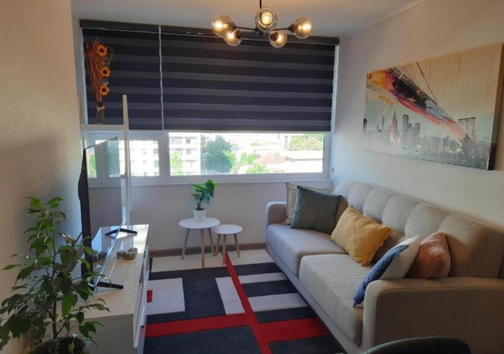 uma sala de estar com um sofá e uma janela em Departamento Excelente Ubicación em Concepción