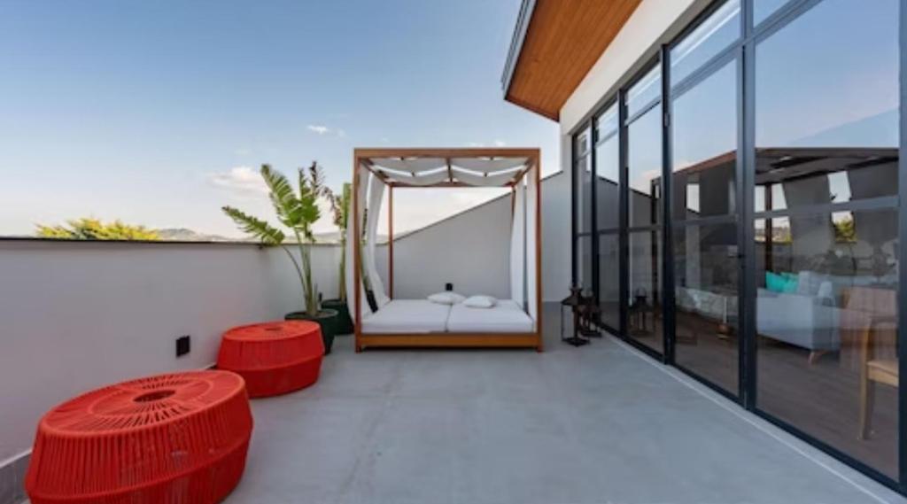 een balkon van een huis met rode krukken bij Wanderlust Experience Hotel, Campos do Jordão in Campos do Jordão