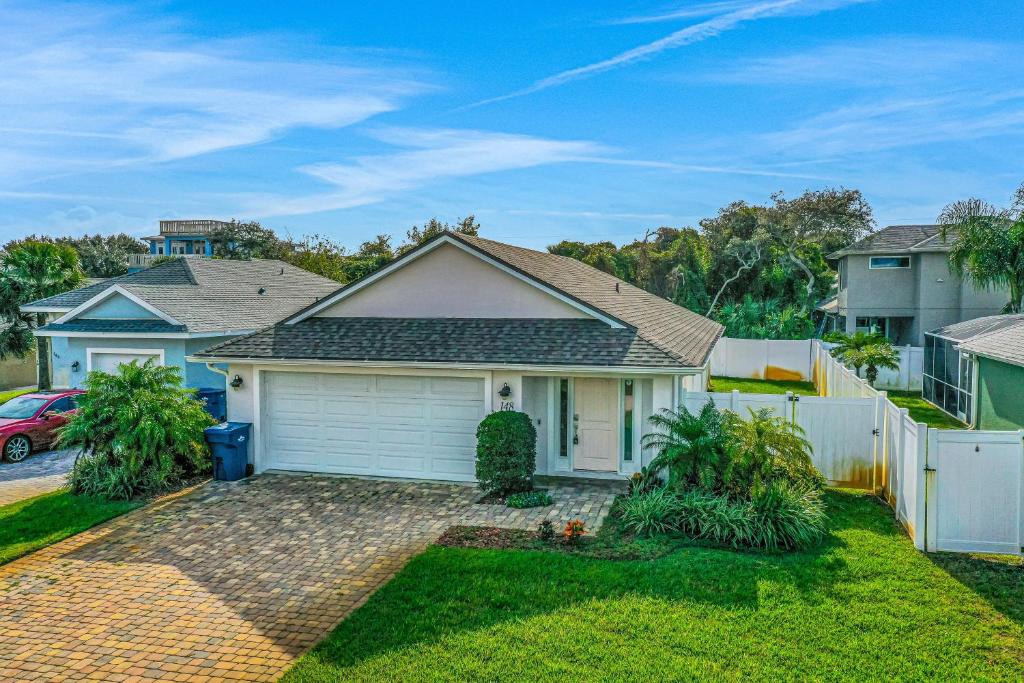 a house with a white garage in a yard at Terrapin Station in Ormond Beach