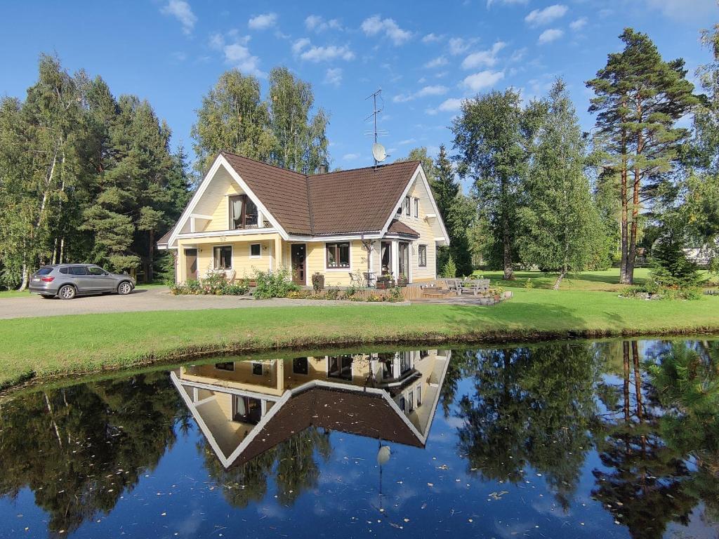 a house with a reflection in the water at Viesu un ciemiņu brīvdienu māja Villa VĒJROZES in Ieriķi