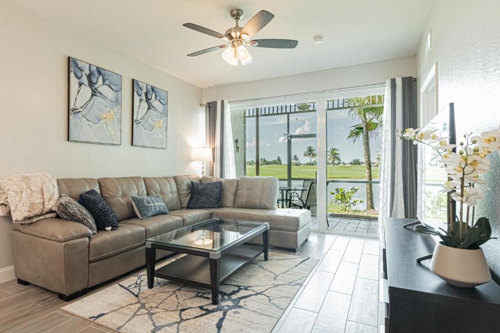 a living room with a couch and a table at Greenlinks at Lely Luxury White Orchid Fully Renovated Modern 1st floor 3bdr Golf Resort Villa in Naples