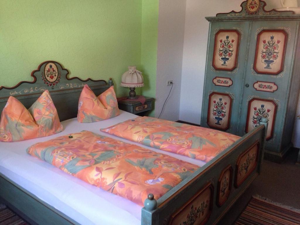 ein Schlafzimmer mit einem großen Bett mit orangefarbener Bettwäsche in der Unterkunft Landgasthof zum Stern in Elfershausen