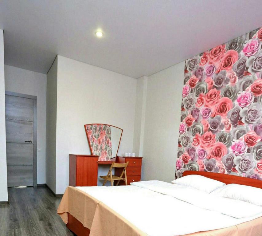 1 dormitorio con 1 cama y una pared con rosas en VIP apart 379, en Tiflis