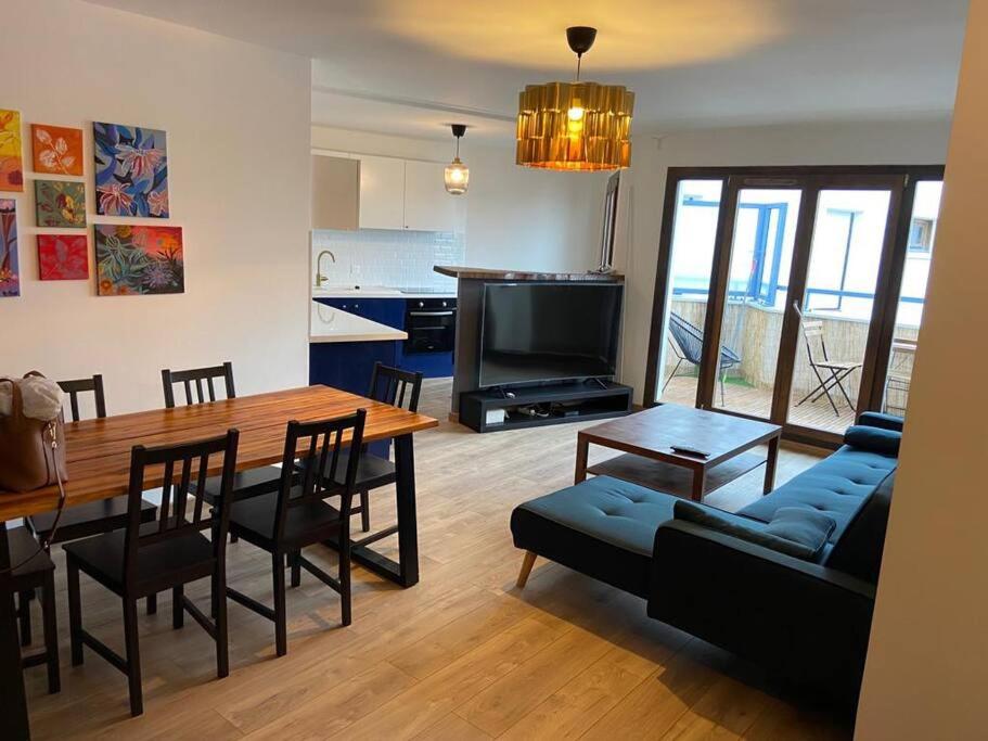 - un salon avec une table et un canapé bleu dans l'établissement 2 bedroom Apartment + Parking, à Saint-Denis