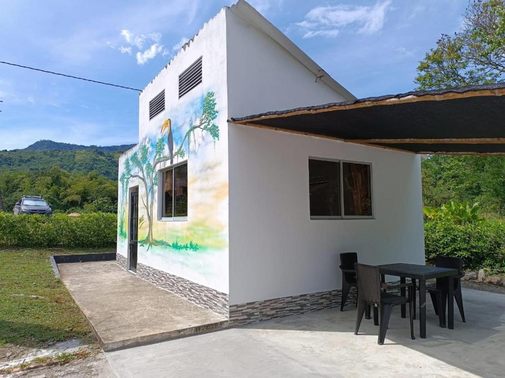 a house with a painting on the side of it at Cabaña Sauce - Villeta in Villeta