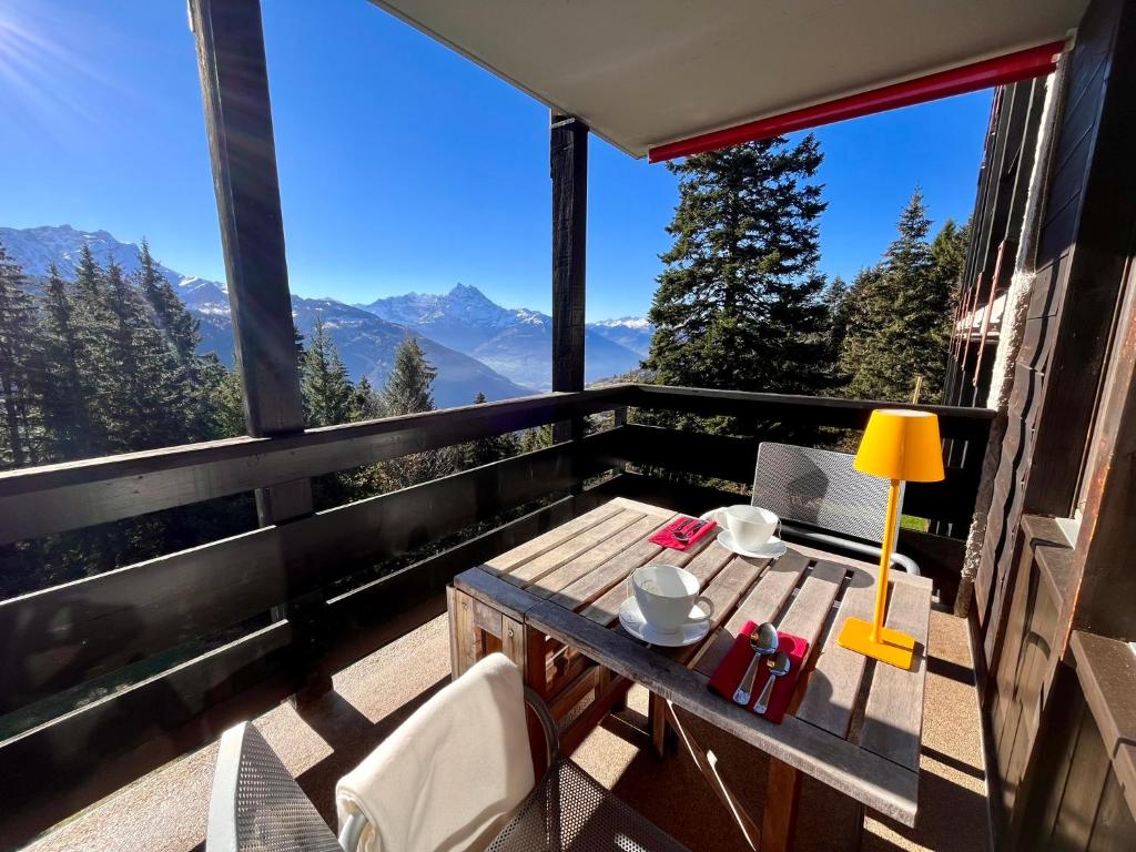 una mesa en un balcón con vistas a las montañas en THE ALPINE STUDIO on the ski slopes - by the lake - Alpe des Chaux - Gryon en Gryon
