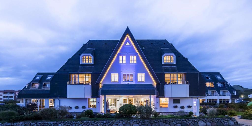 a large house with a black roof at Dorint Strandresort & Spa Westerland/Sylt in Westerland