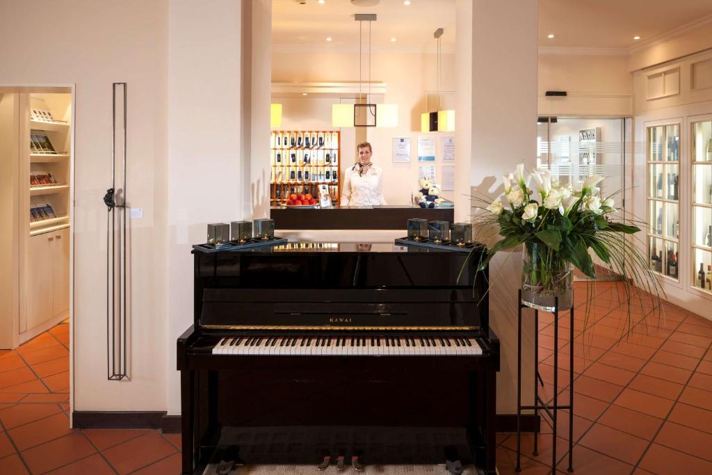 a man standing behind a piano in a store at Dorint Strandresort & Spa Westerland/Sylt in Westerland