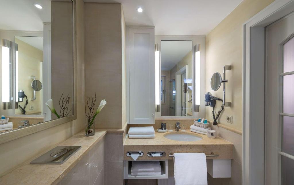 a bathroom with a sink and a large mirror at Dorint Strandresort & Spa Westerland/Sylt in Westerland