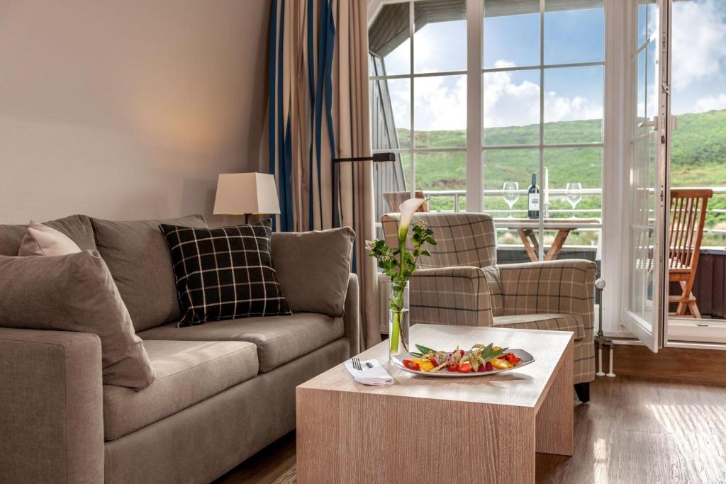a living room with a couch and a table at Dorint Strandresort & Spa Westerland/Sylt in Westerland