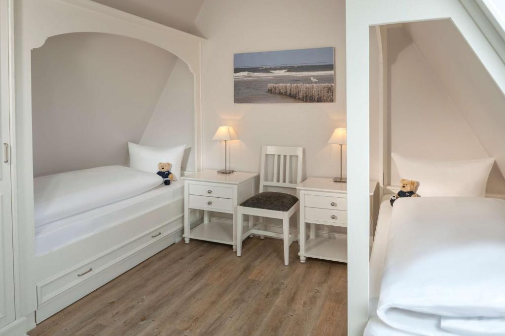 a bedroom with a bed and a desk with a chair at Dorint Strandresort & Spa Westerland/Sylt in Westerland