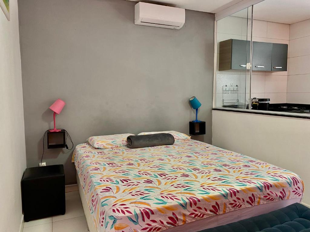 a bedroom with a bed with a colorful comforter at Sunset Maresias -Casas e Chalés C2 in Maresias