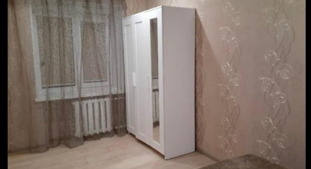 einen weißen Schrank in einem Zimmer mit Fenster in der Unterkunft VIP apart 384 in Tbilisi City