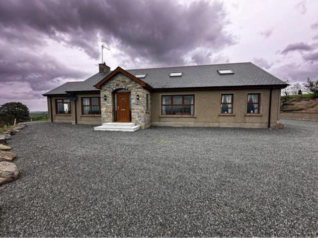 una casa con una entrada de grava delante de ella en Montana, en Castlewellan