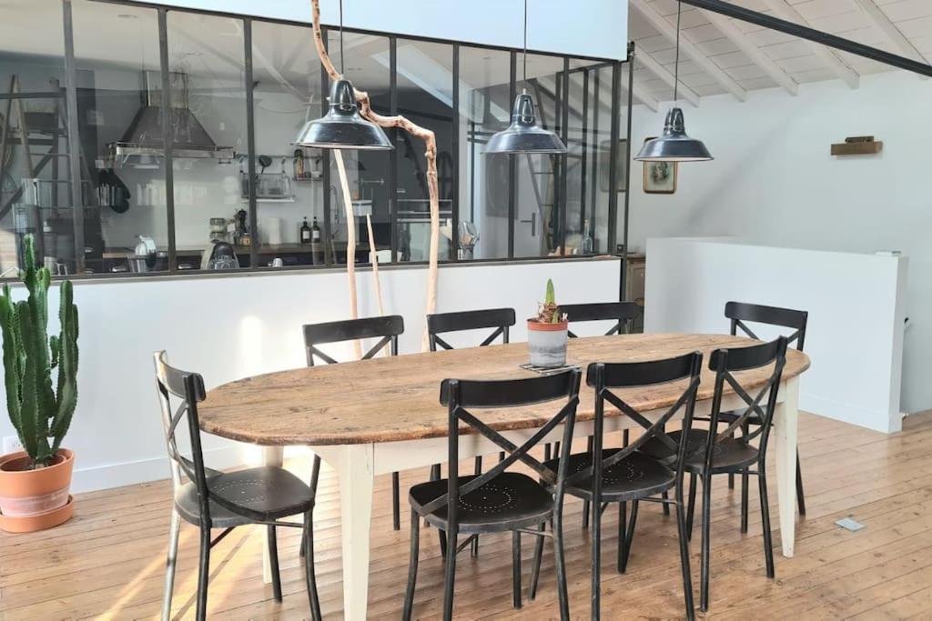 a wooden table and chairs in a room at Maison et studio indépendant - Chez Lulu in Vertou