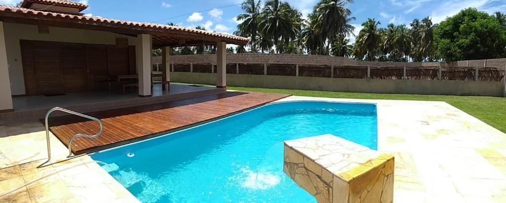 una piscina en un patio junto a una casa en Recanto São Miguel dos Milagres, en São Miguel dos Milagres