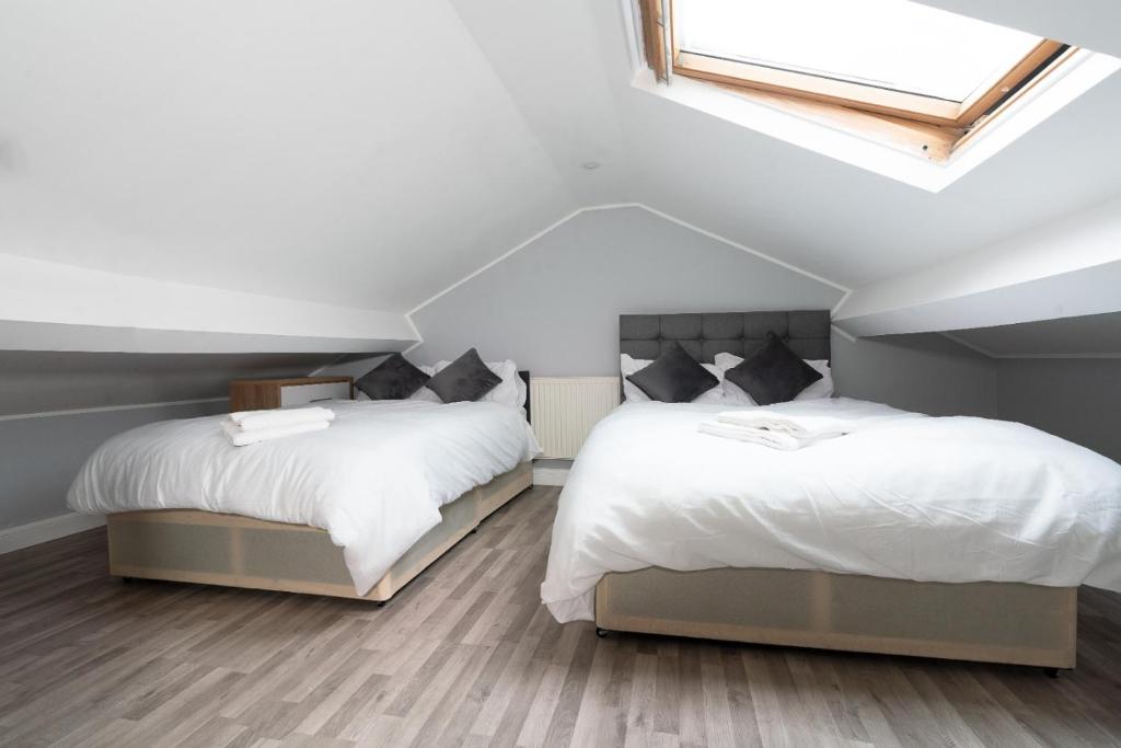 sypialnia na poddaszu z 2 łóżkami i świetlikiem w obiekcie Modern Apartment in Liverpool City Centre w Liverpoolu