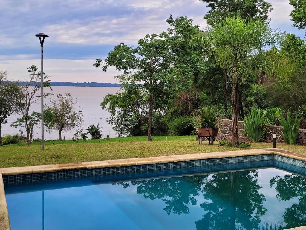 a swimming pool with a view of the water at Casa sobre el río in Posadas