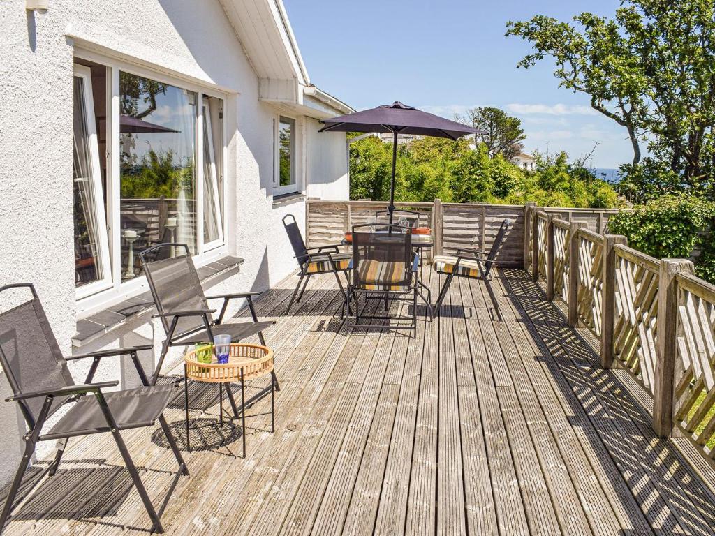 a deck with chairs and a table with an umbrella at Top Deck in Gorran Haven