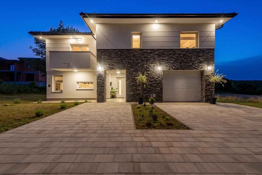 a large house with a garage at night at Apartments and rooms with parking space Grabovac, Plitvice - 21931 in Rakovica