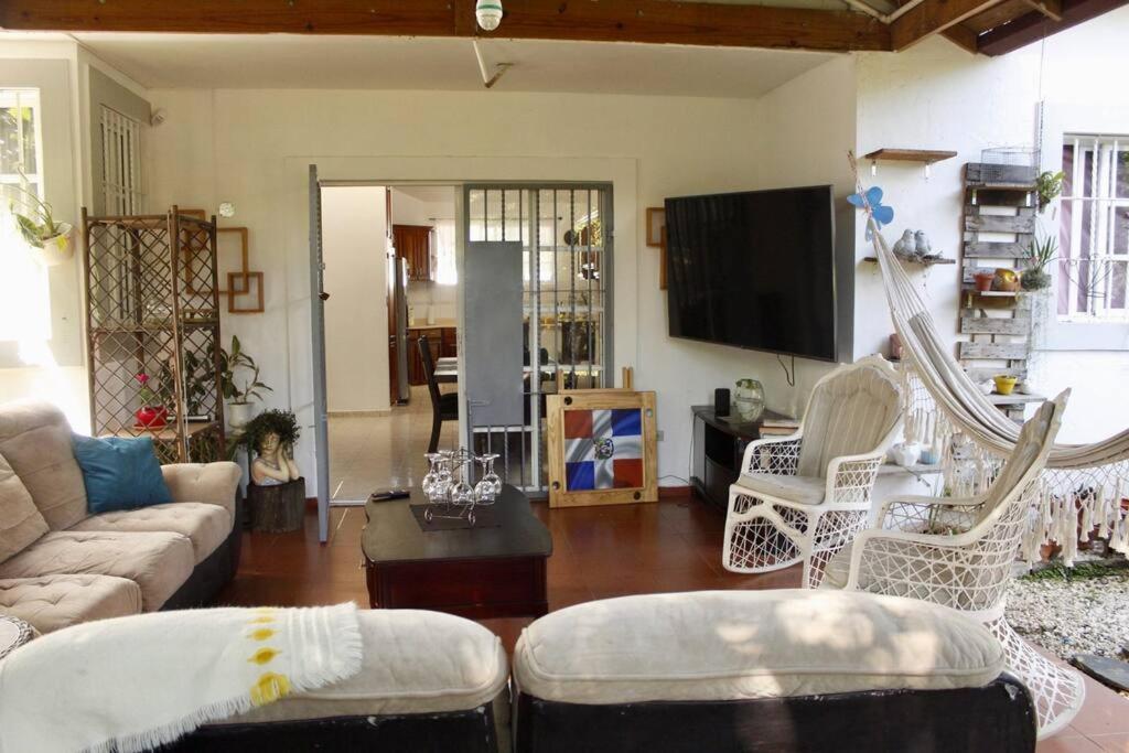 a living room with a couch and a tv at Relax House in Concepción de La Vega