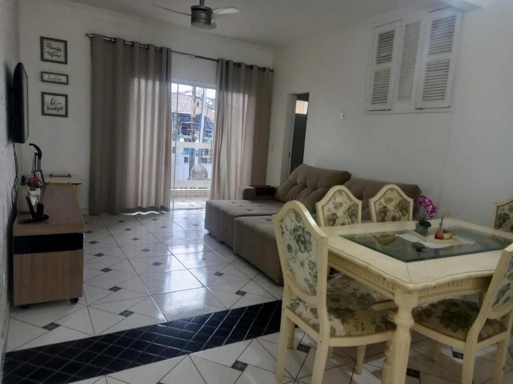 a living room with a couch and a table and chairs at Locação Casa Residencial Guarujá - Alta Temporada in Guarujá