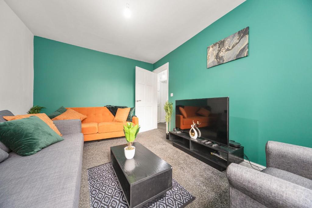 ein Wohnzimmer mit einem Sofa und einem Flachbild-TV in der Unterkunft Exclusive house for contractors and families in Buttershaw