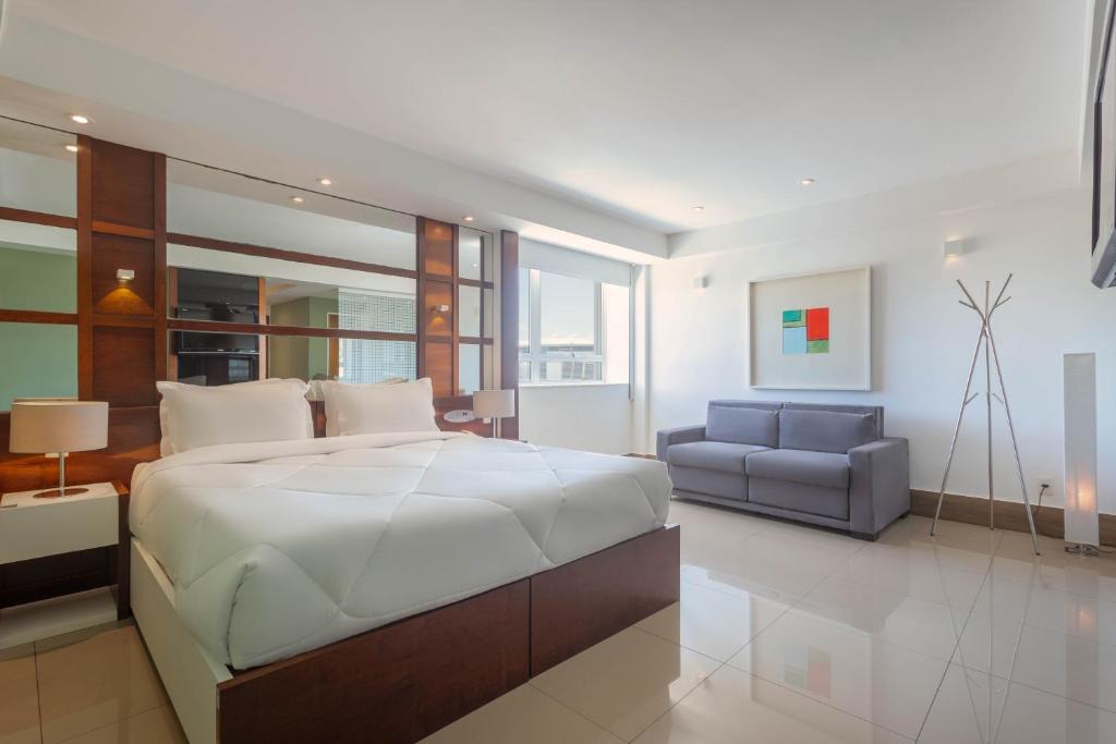 里約熱內盧的住宿－TRYP by Wyndham Rio de Janeiro Barra Parque Olímpico，一间卧室配有一张大床和一张沙发