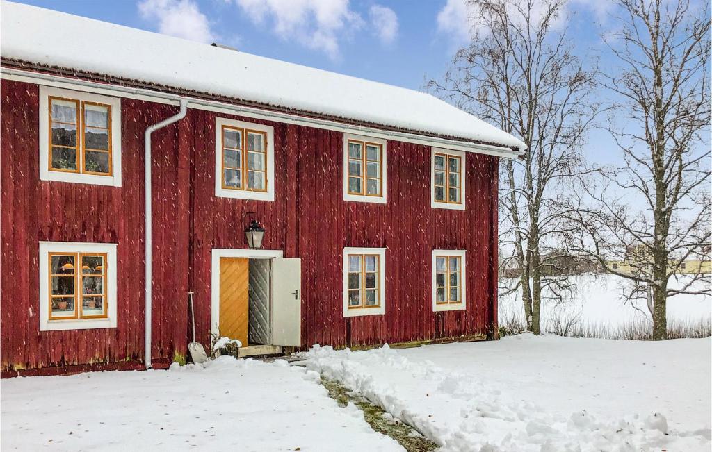 un granero rojo con nieve en el suelo en Nice Home In Klubbcken With Sauna, 